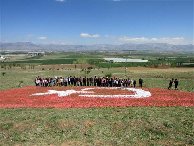 ÇAKIL TAŞLARIYLA YAPTIĞI 217 METREKARELİK TÜRK BAYRAĞINI ÇOCUKLARA ARMAĞAN ETTİ